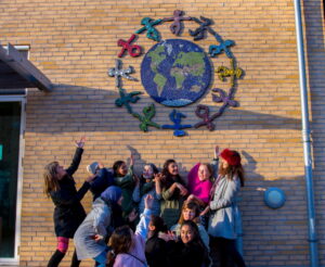 mosaikkunst mosaik på skole, jordkloden med dansende figurer omkring Strandgårdsskolen