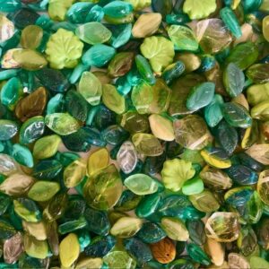 små glasblade glasperler formet som perler i grønne nuancer